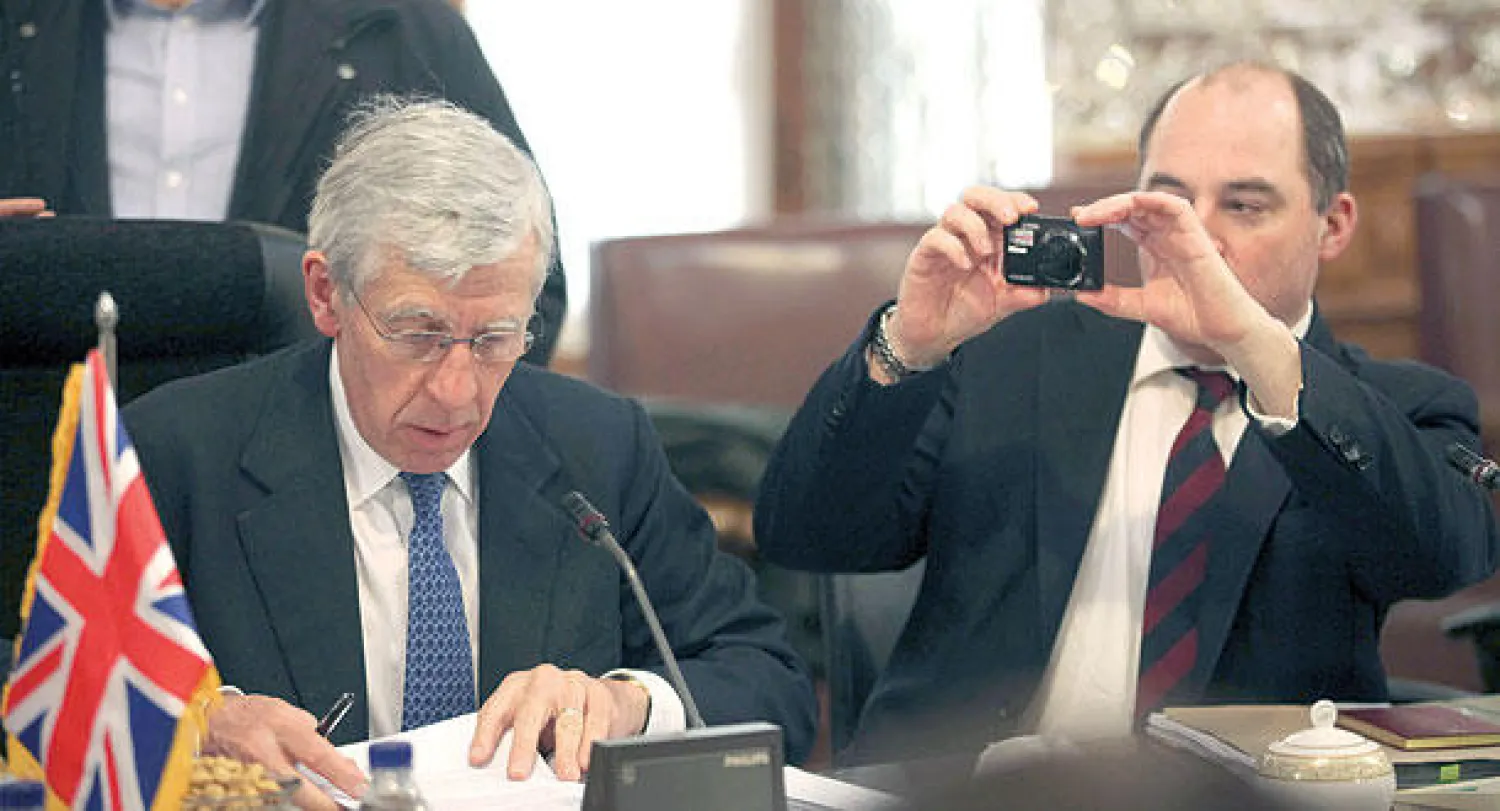 مرافق لوزير الخارجية البريطاني الأسبق جاك سترو يلتقط له صورة قبل بدء اجتماع مع نواب إيرانيين  في طهران، أمس (أ.ب)