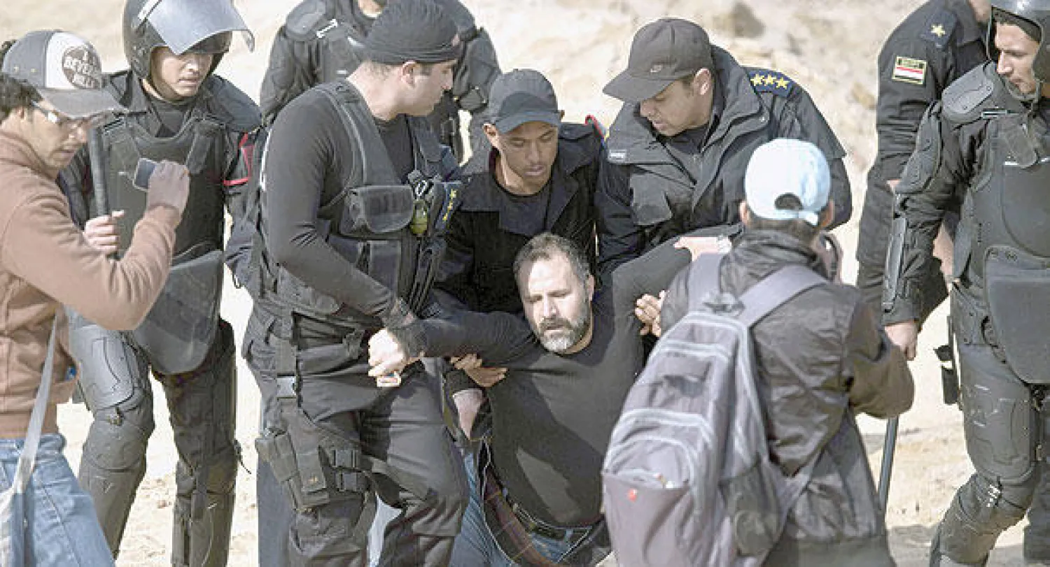 قوات الشرطة تعتقل أحد أنصار جماعة الإخوان أمام مقر محاكمة الرئيس المعزول محمد مرسي شرق القاهرة أمس (أ.ف.ب)