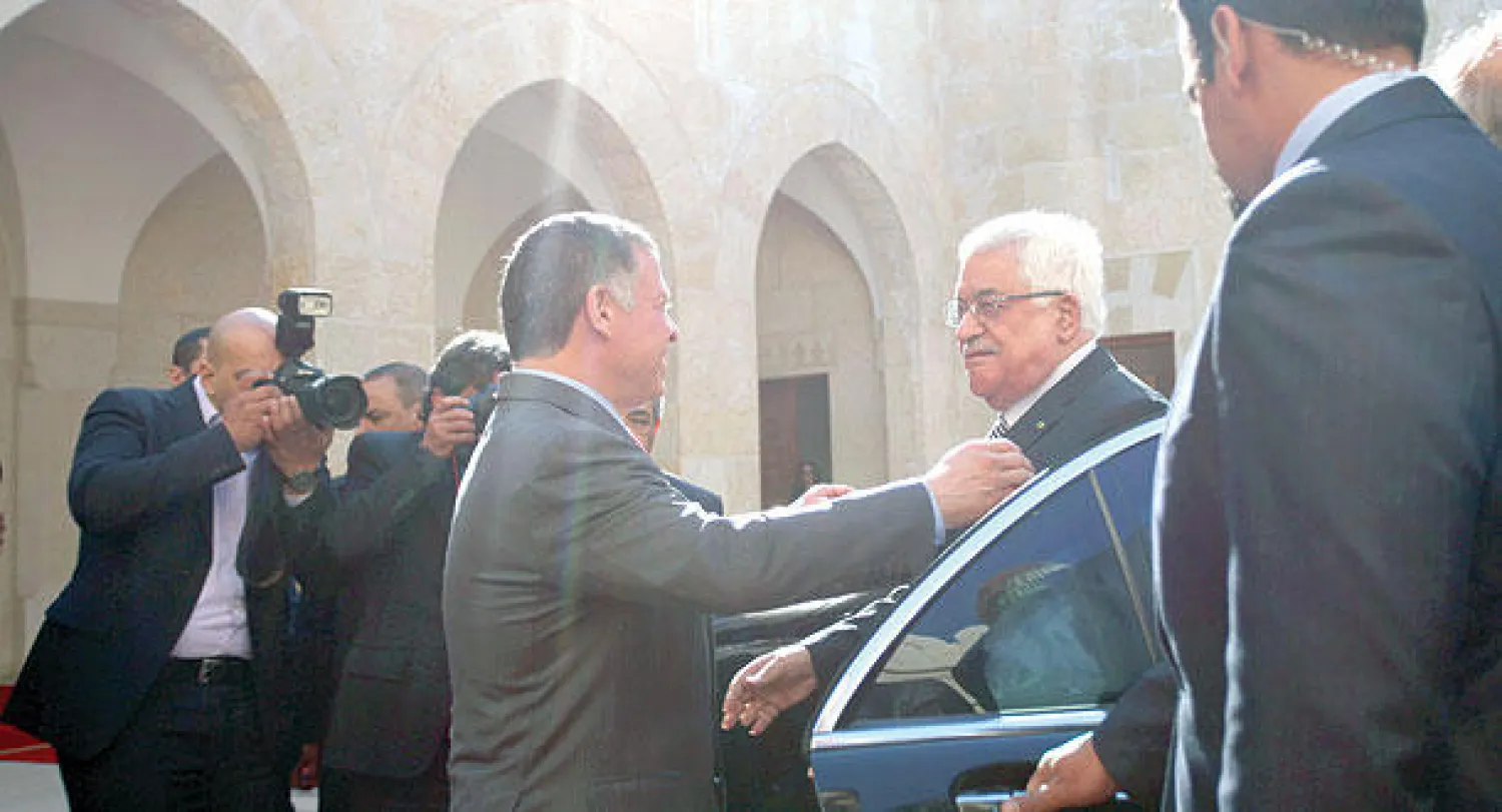 العاهل الأردني الملك عبد الله الثاني مستقبلا الرئيس الفلسطيني محمود عباس في عمان أمس (أ.ب)