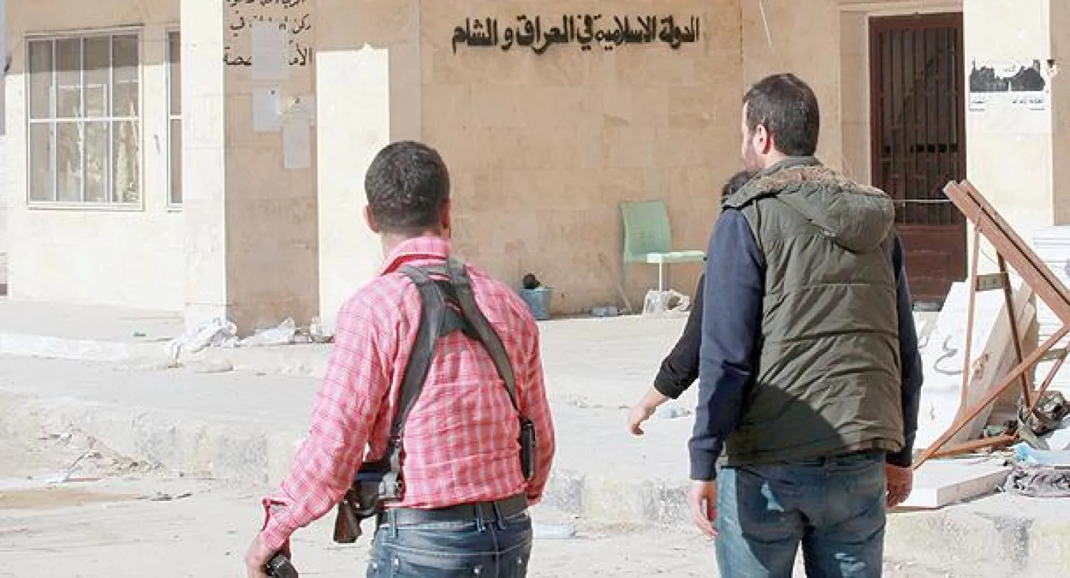 مقاتلون من «الجيش السوري الحر» يتجولون في مقر «داعش» الرئيس في مدينة حلب بعد سقوطه أمس (رويترز)