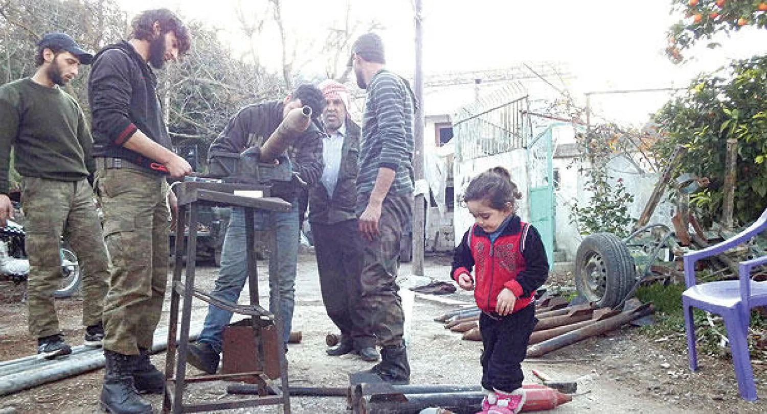 مقاتلون معارضون للنظام السوري يصنعون قذائف بدائية في ريف اللاذقية (رويترز)