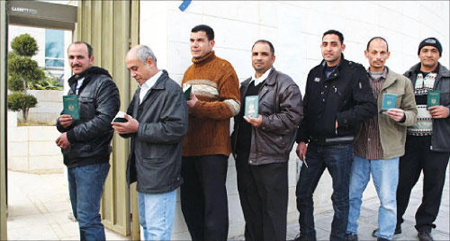 مصريون يتنظرون دورهم للإدلاء بأصواتهم على الدستور خارج سفارة بلادهم في الأردن أمس (رويترز)