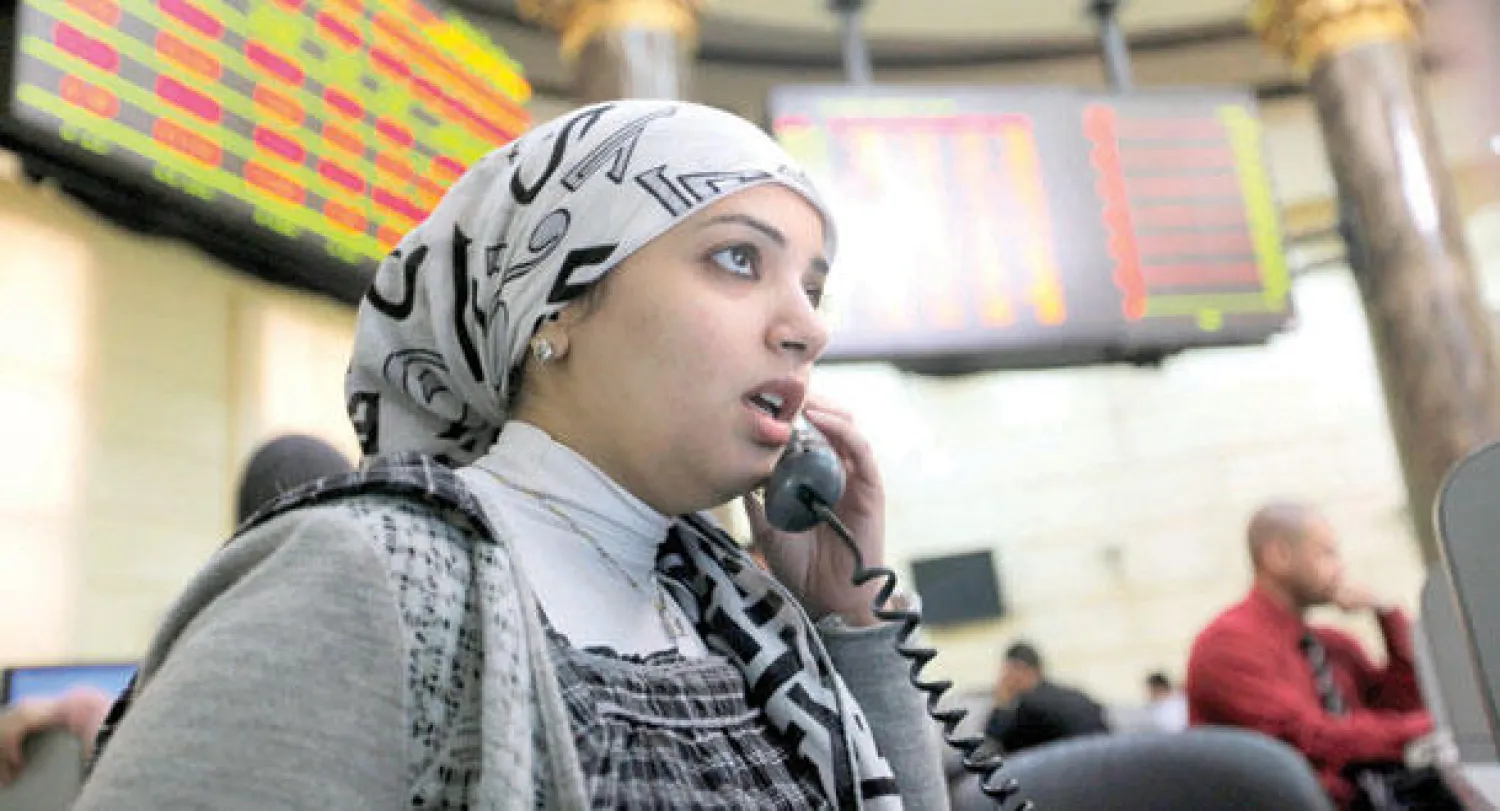 متعاملة مصرية تتابع مؤشر سوق البورصة في القاهرة أمس (أ.ب)