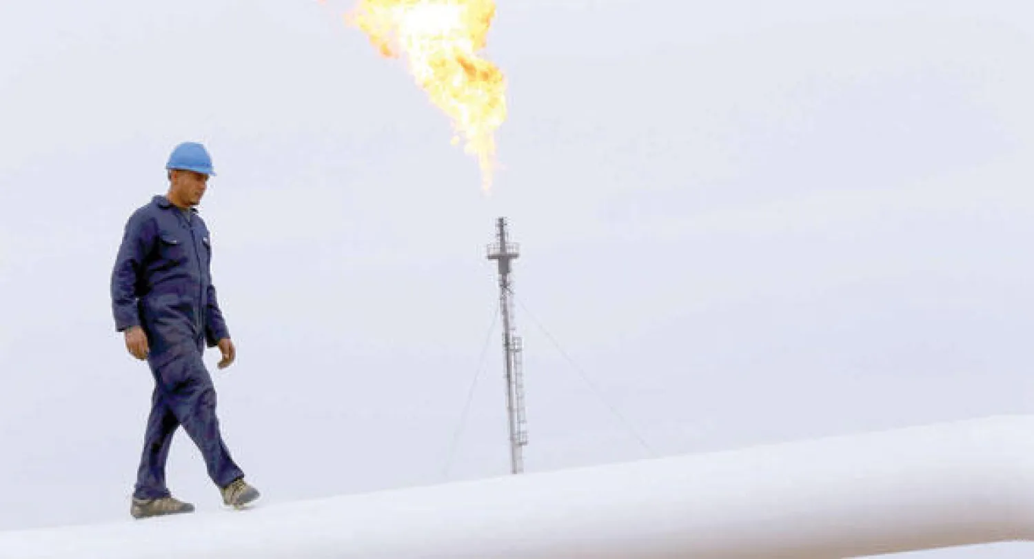 عامل يسير على خط أنابيب نفط في حقل خورمالا القريب من أربيل (رويترز)