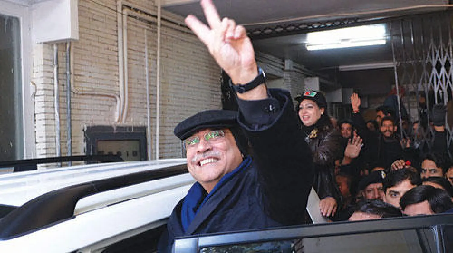 زرداري يلوح بعلامة النصر أثناء مغادرته المحكمة في إسلام آباد أمس (أ.ف.ب)