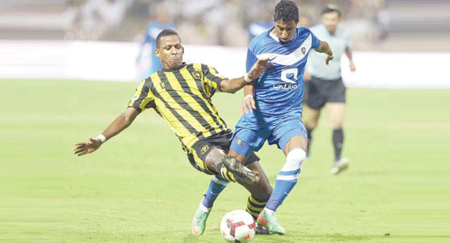 أبو سبعان لاعب الاتحاد يحاول قطع الكرة من لاعب الهلال سالم الدوسري خلال مباراة الفريقين أمس الأول (تصوير: عدنان مهدلي)