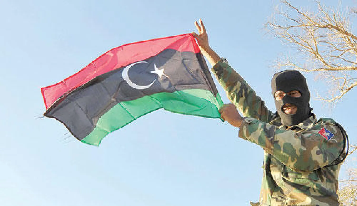 عنصر من الجيش الليبي يرفع العلم استعدادا لتحرك الجيش نحو مدينة بنغازي (رويترز)