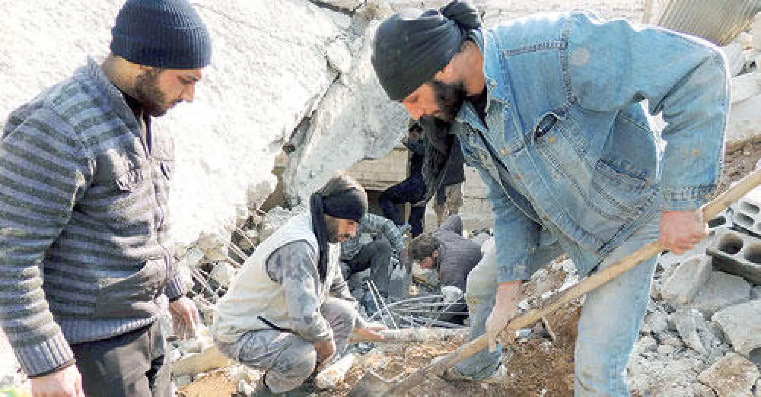 سوريون يزيلون ركام بنايات تدمرت جراء قصف حكومي في الغوطة الشرقية قرب دمشق أمس (رويترز)