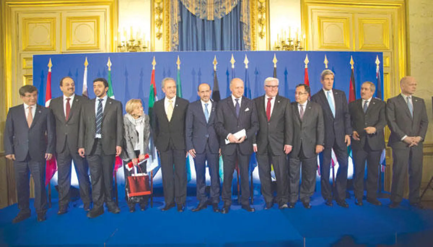 الأمير سعود الفيصل، وإلى يساره رئيس الائتلاف الوطني السوري المعارض أحمد الجربا، يتوسطان وزراء خارجية الدول الأساسية لـ«أصدقاء سوريا» بعد اجتماعهم في باريس أمس (أ.ب)