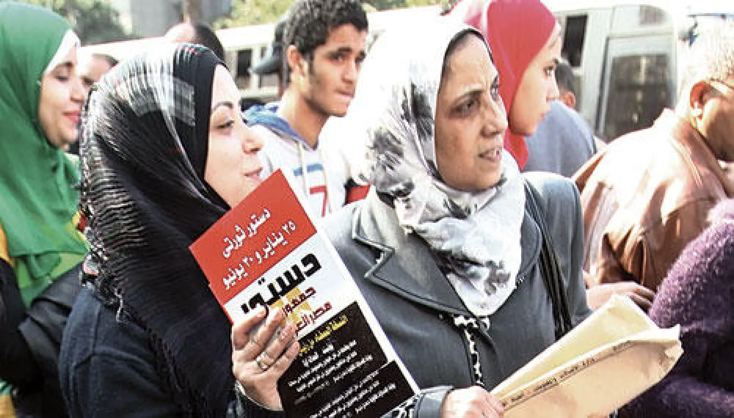 سيدات مصريات يحملن نسخا من الدستور الجديد في وسط القاهرة قبل التصويت عليه الثلاثاء والأربعاء المقبلين (إ.ب.أ)