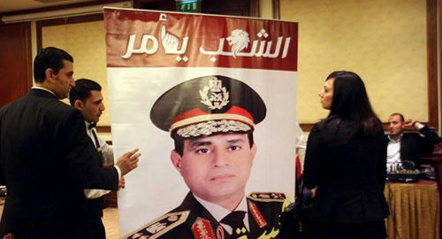 مؤيدون للفريق أول عبد الفتاح السيسي النائب الأول لرئيس مجلس الوزراء وزير الدفاع والإنتاج الحربي يرفعون لافتة كبيرة تحمل صورته وعبارة «الشعب يأمر» في وسط القاهرة أمس (أ.ب)