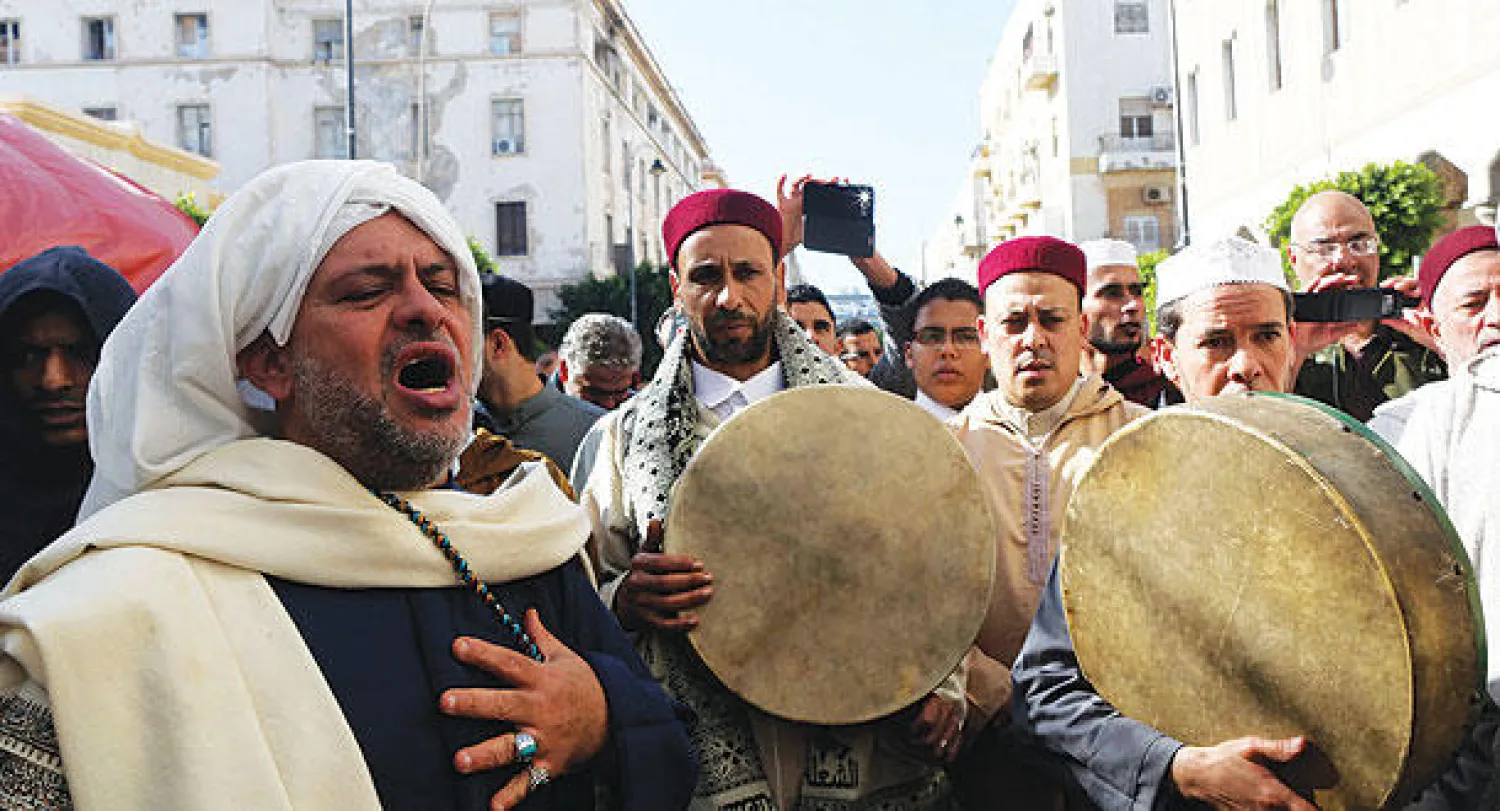 مواطنون وتابعون لإحدى الطرق الصوفية خلال الاحتفال بالمولد النبوي الشريف في مدينة بنغازي الليبية أمس (رويترز)