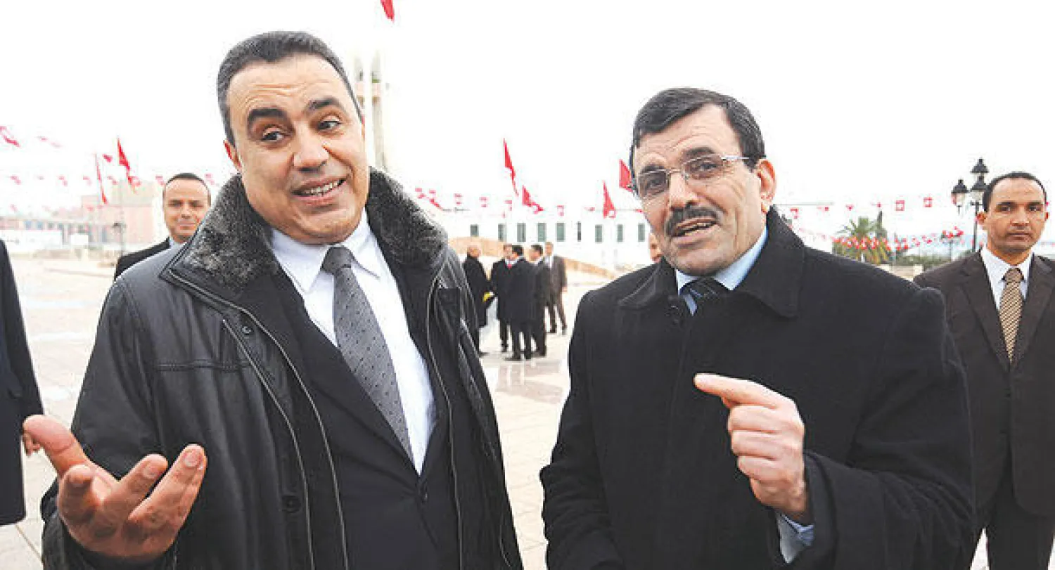 رئيس الحكومة التونسي المستقيل (يمين) علي العريض والرئيس الجديد المكلف تشكيل الحكومة المهدي جمعة أثناء الاحتفالات بالذكرى الثالثة للإطاحة ببن علي في تونس أمس (أ.ف.ب)