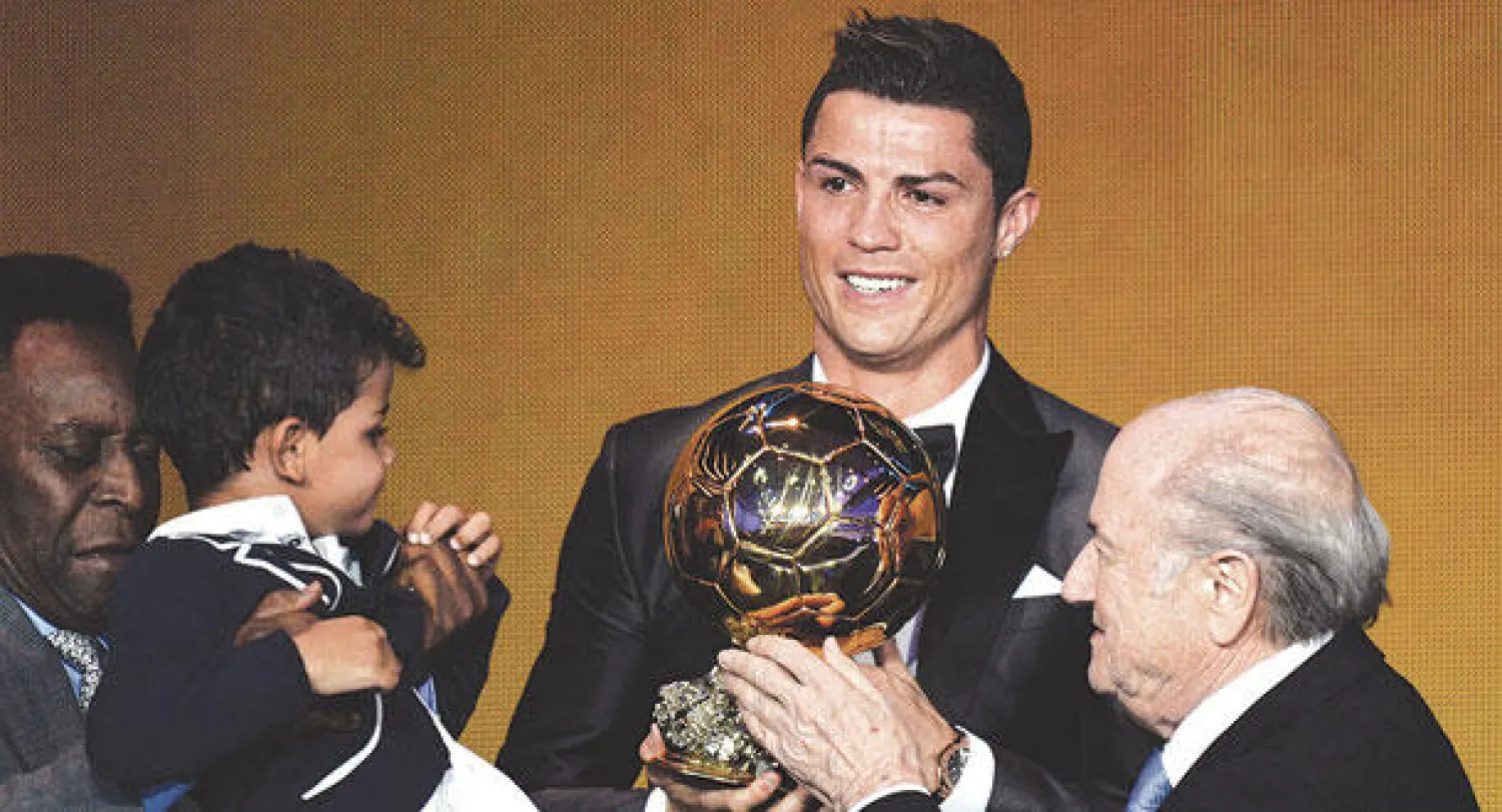 رونالدو يتسلم الجائزة من بلاتر وبجانبه ابنه الصغير مع الأسطورة بيليه (إ.ب.أ)