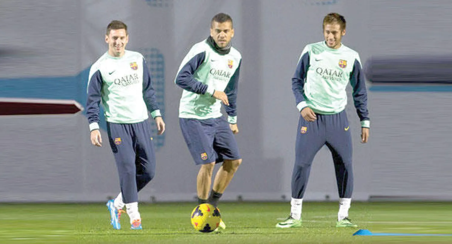 مدافع برشلونة دانييل ألفيس يتوسط ميسي (يسار) ونيمار