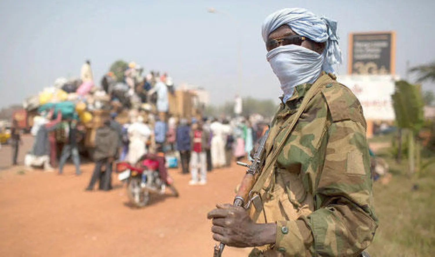 جندي تشادي ضمن قوة السلام الأفريقية يحرس عملية ترحيل مدنيين باتجاه بلاده في بانغي أمس (رويترز)