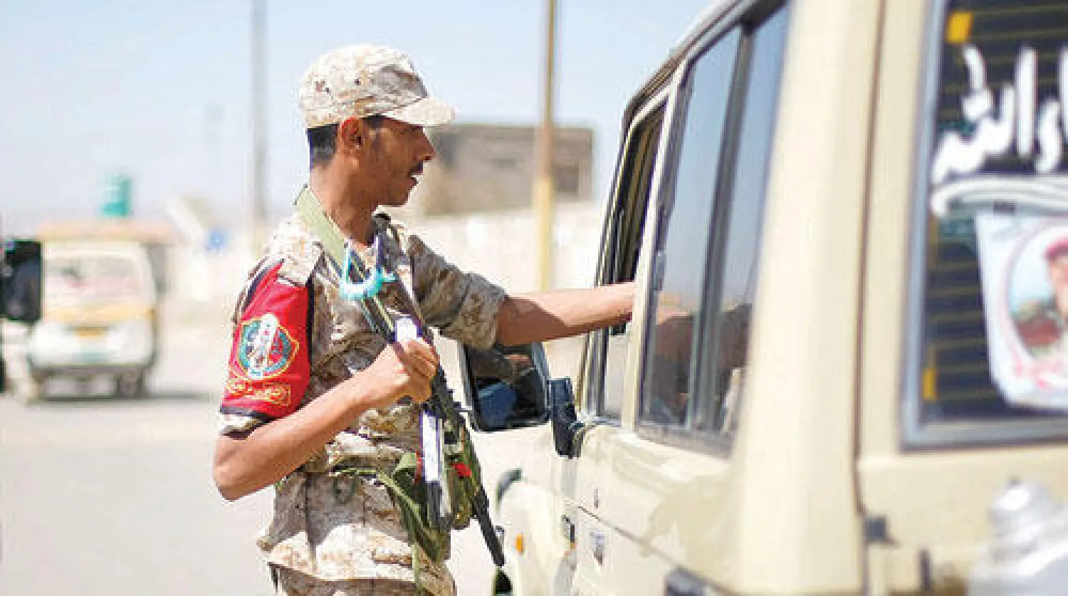 جندي يمني يفحص هوية سائق سيارة عند إحدى نقاط التفتيش بأحد شوارع صنعاء أمس (أ.ب)