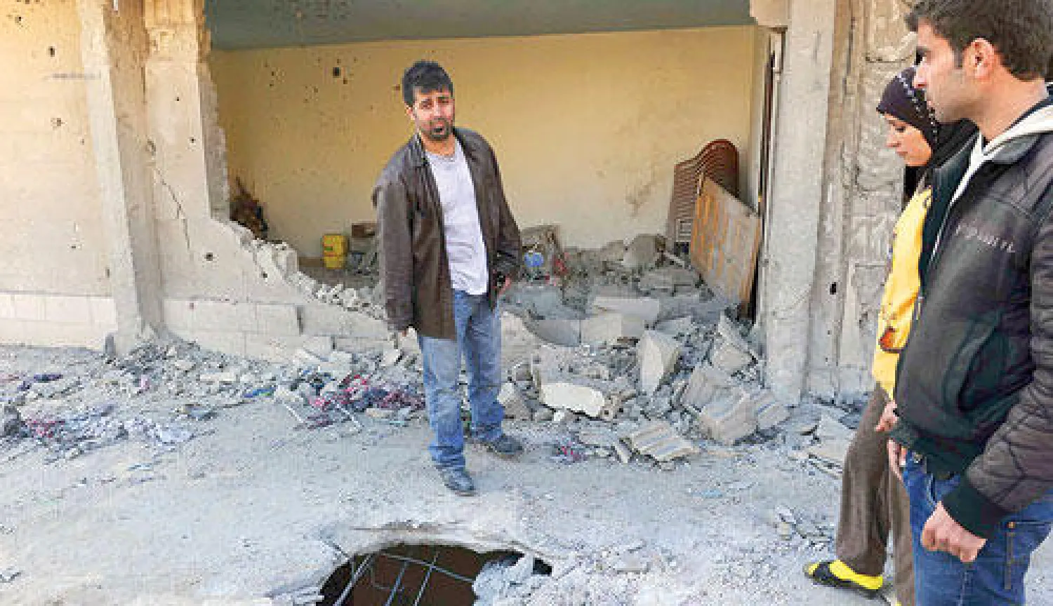 لبنانيون يعاينون آثار سقوط القذائف على بلدة عرسال الحدودية أمس (رويترز)