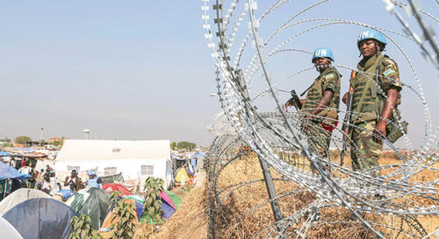 جنود روانديون يقومون بحراسة معسكر للنازحين قرب جوبا أمس (إ.ب.أ)