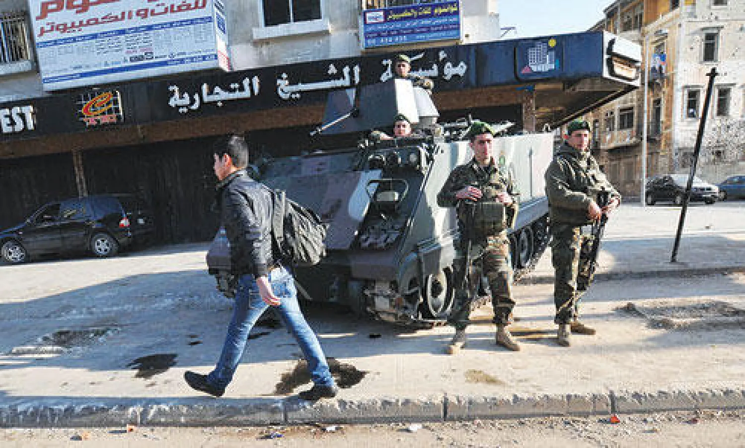 لبناني يسير قرب نقطة تفتيش أقامها عناصر الجيش في طرابلس أمس (أ.ف.ب)