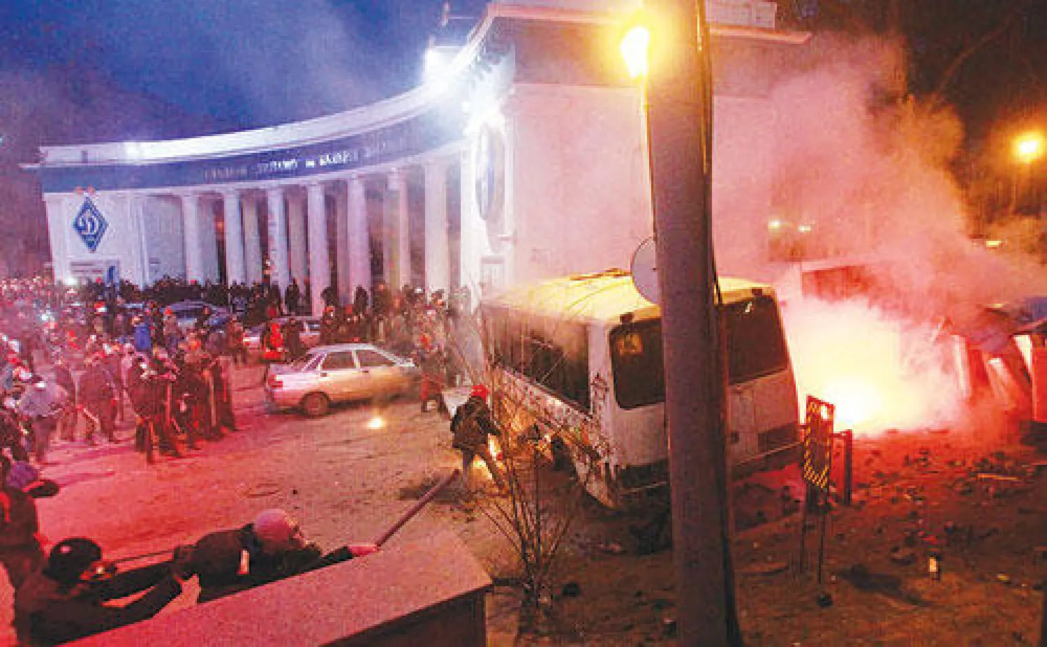 متظاهرون يضرمون النار بقافلة تابعة للشرطة بالقرب من مبان حكومية وسط كييف أمس (رويترز)