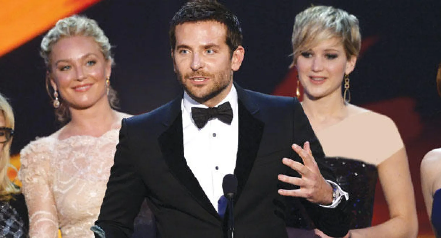 برادلي كوبر وجينيفر لورانس وإليزابيث روم الحاصلون على جائزة أفضل فريق تمثيل عن فيلم «أميركان هاسل» (أ.ف.ب)