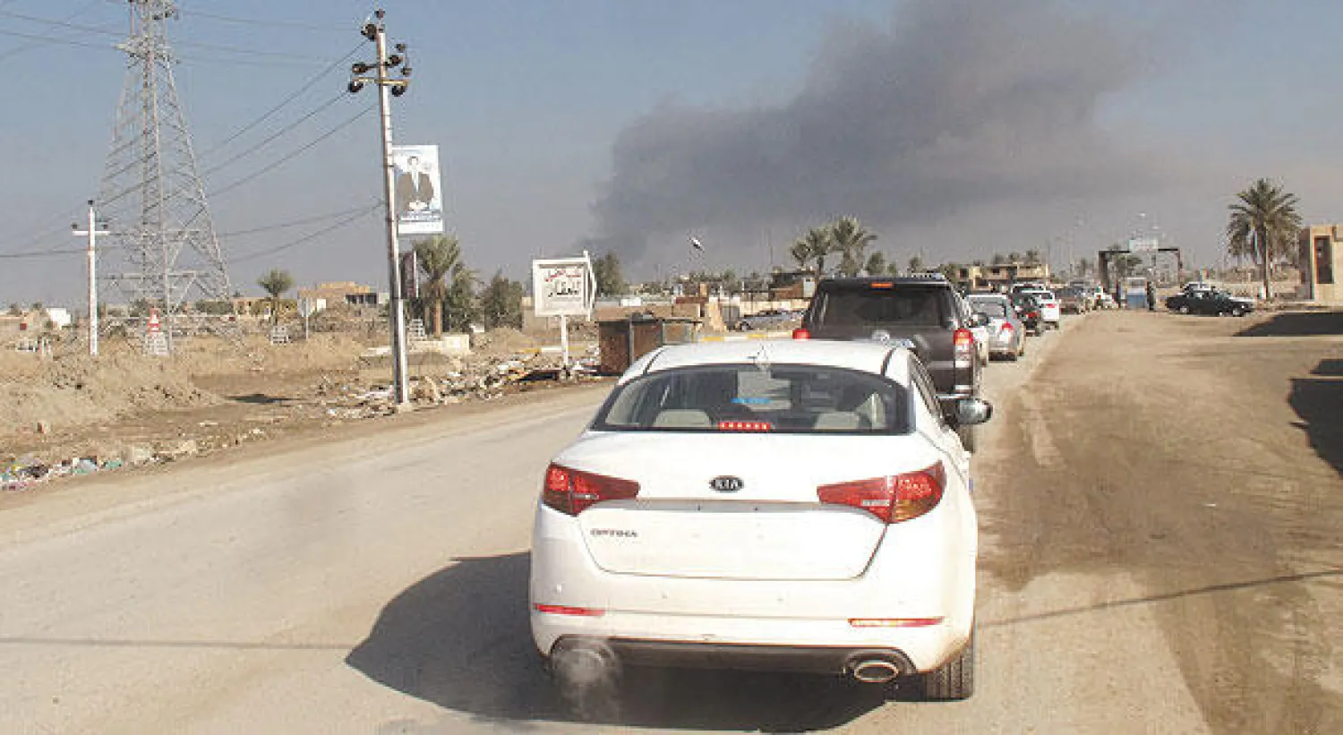 سيارات تتوجه إلى منطقة البوفراج شمال الرمادي حيث يرتفع الدخان من موقع انفجار أمس (أ.ف.ب)