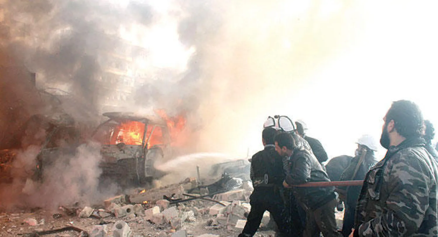 إطفائيون يحاولون إخماد حريق في مبنى استهدفته طائرات النظام في حي الفردوس وسط حلب أمس (أ.ف.ب)