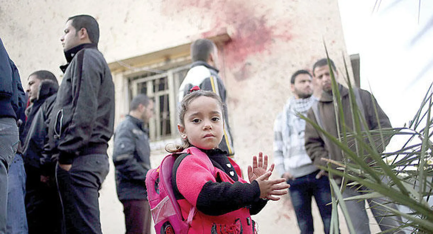 طفلة فلسطينية مع آخرين بعد غارة إسرائيلية استهدفت قياديا في حركة الجهاد الإسلامي في بيت حانون شمال قطاع غزة أمس (إ.ب.أ)