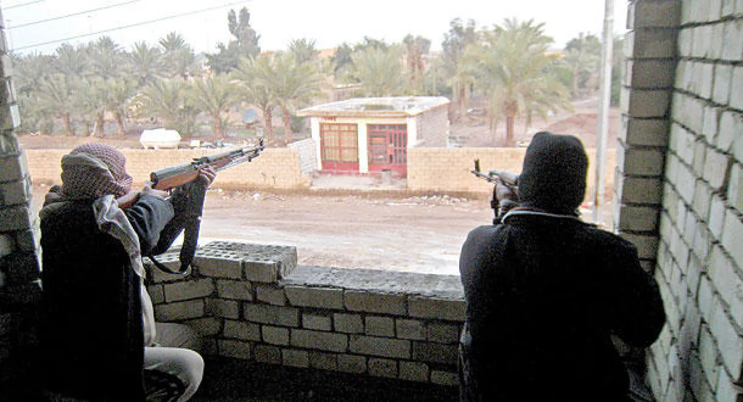 مسلحان يراقبان من بناية أحد شوارع الفلوجة أمس (أ.ب)