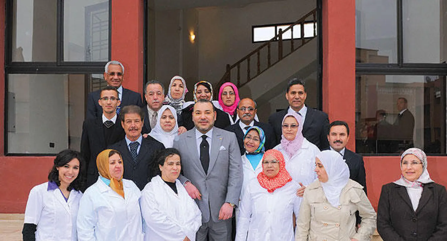 الملك محمد السادس في صورة تذكارية مع موظفي المركز التربوي بعد تدشينه أمس في مراكش (ماب)