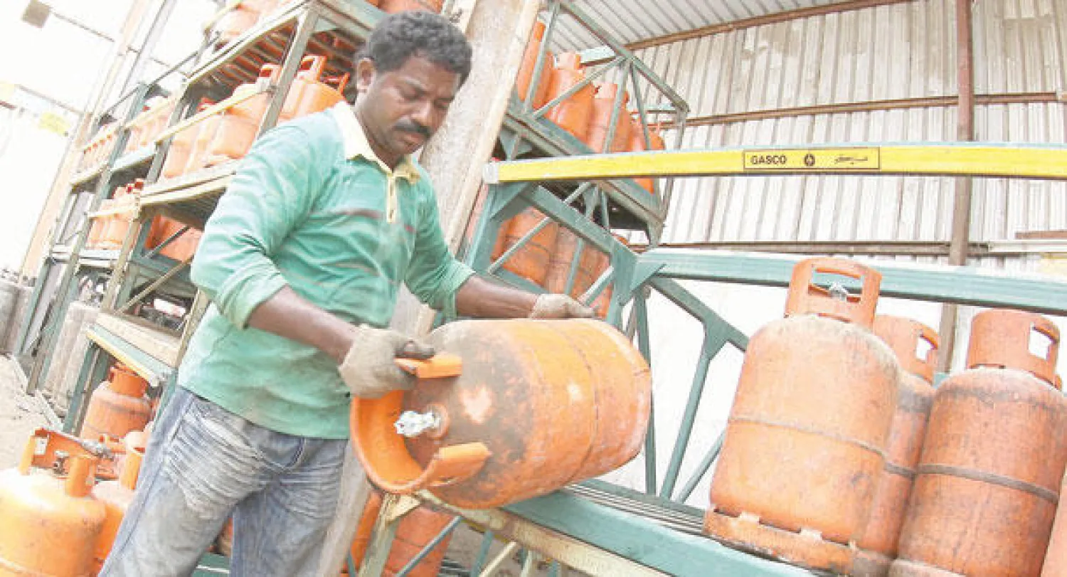 عامل يباشر تبديل أسطوانات الغاز، ويبدو استخدام الأنواع القديمة التي تشكل خطرا على السلامة («الشرق الأوسط»)