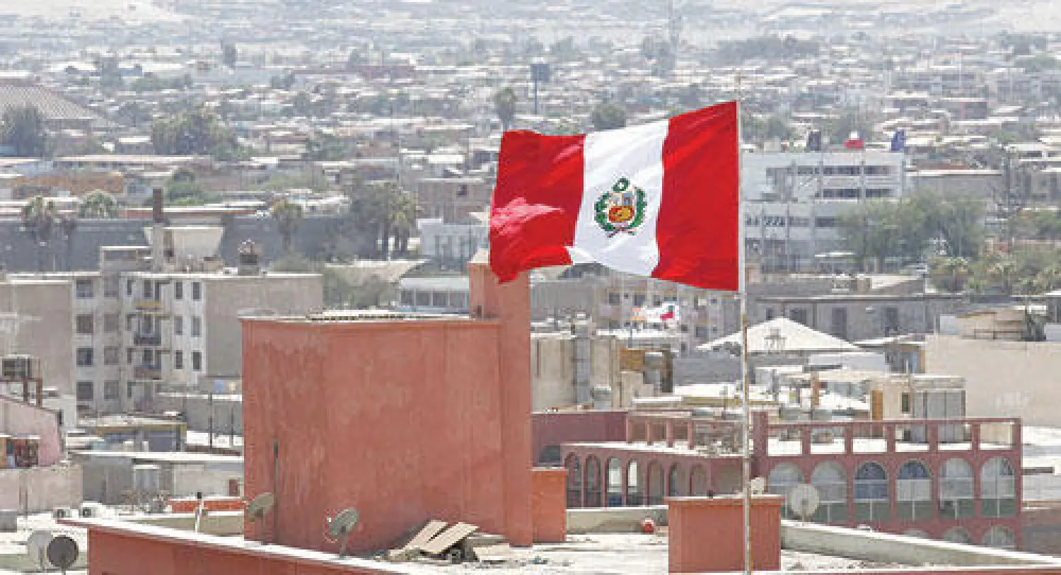 علم بيروفي يرفرف فوق سفارة بيرو في مدينة أريكا بشمال تشيلي قرب الحدود مع بيرو أمس (إ.ب.أ)