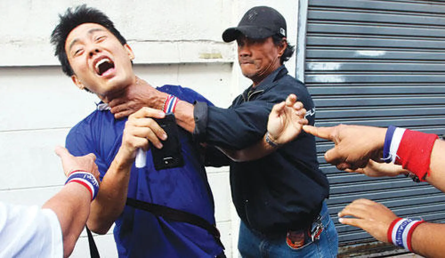 محتج تايلاندي يهاجم مواطن ذهب للتصويت المبكر في انتخابات العاصمة بانكوك أمس (إ.ب.أ)