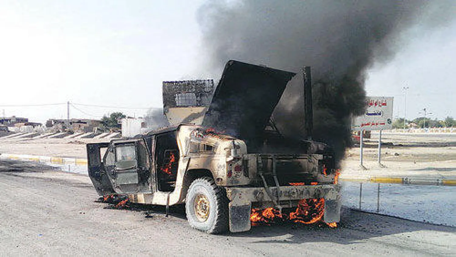 الدخان يتصاعد من عربة عسكرية بعد أن هاجمها مسلحون في الفلوجة أمس (أ.ف.ب)