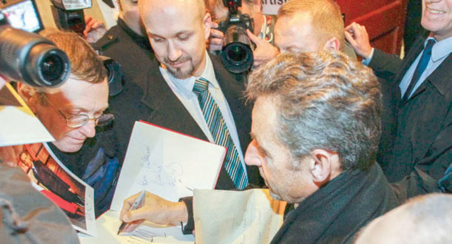 ساركوزي يوقع على أوتوغراف أثناء وصوله لحضور حفل غنائي لزوجته كارلا بروني في مدينة ليون الأسبوع الماضي (رويترز)