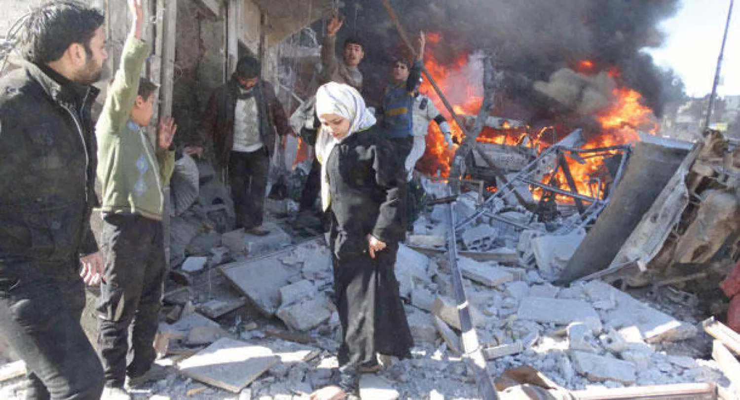 سوريون يتفحصون الدمار الذي سببه قصف جوي على منطقة الباب في حلب أمس (أ.ف.ب)