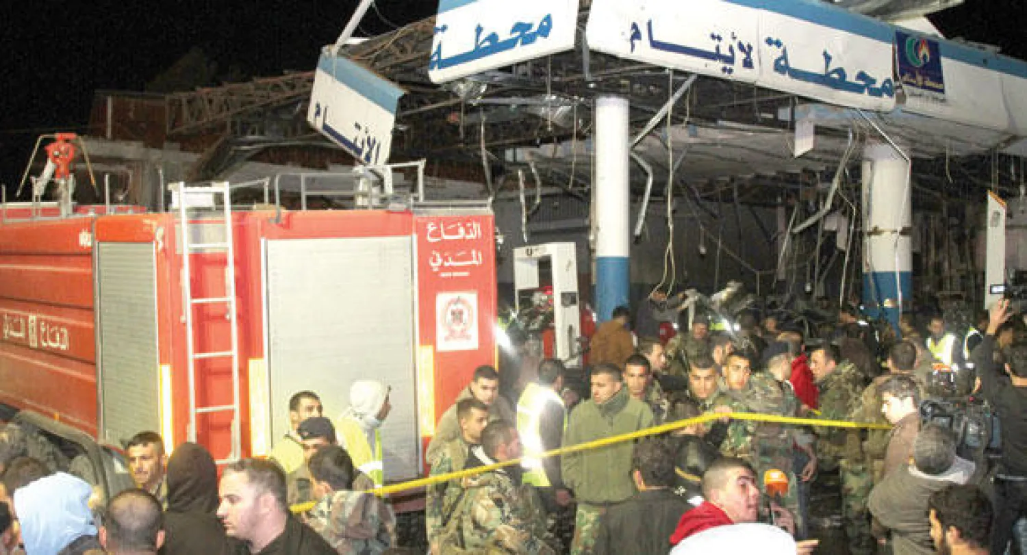 رجال الإنقاذ يفحصون آثار الدمار في إحدى محطات الوقودالتي تسبب فيها انفجار سيارة مفخخة في منطقة الهرمل أمس (أ.ف.ب)