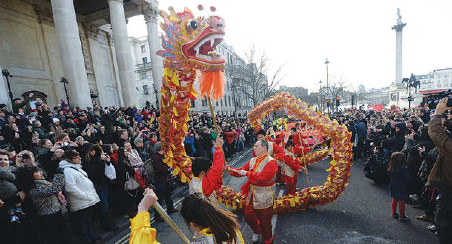 صينيون يقدمون رقصة التنين في وسط لندن (رويترز)