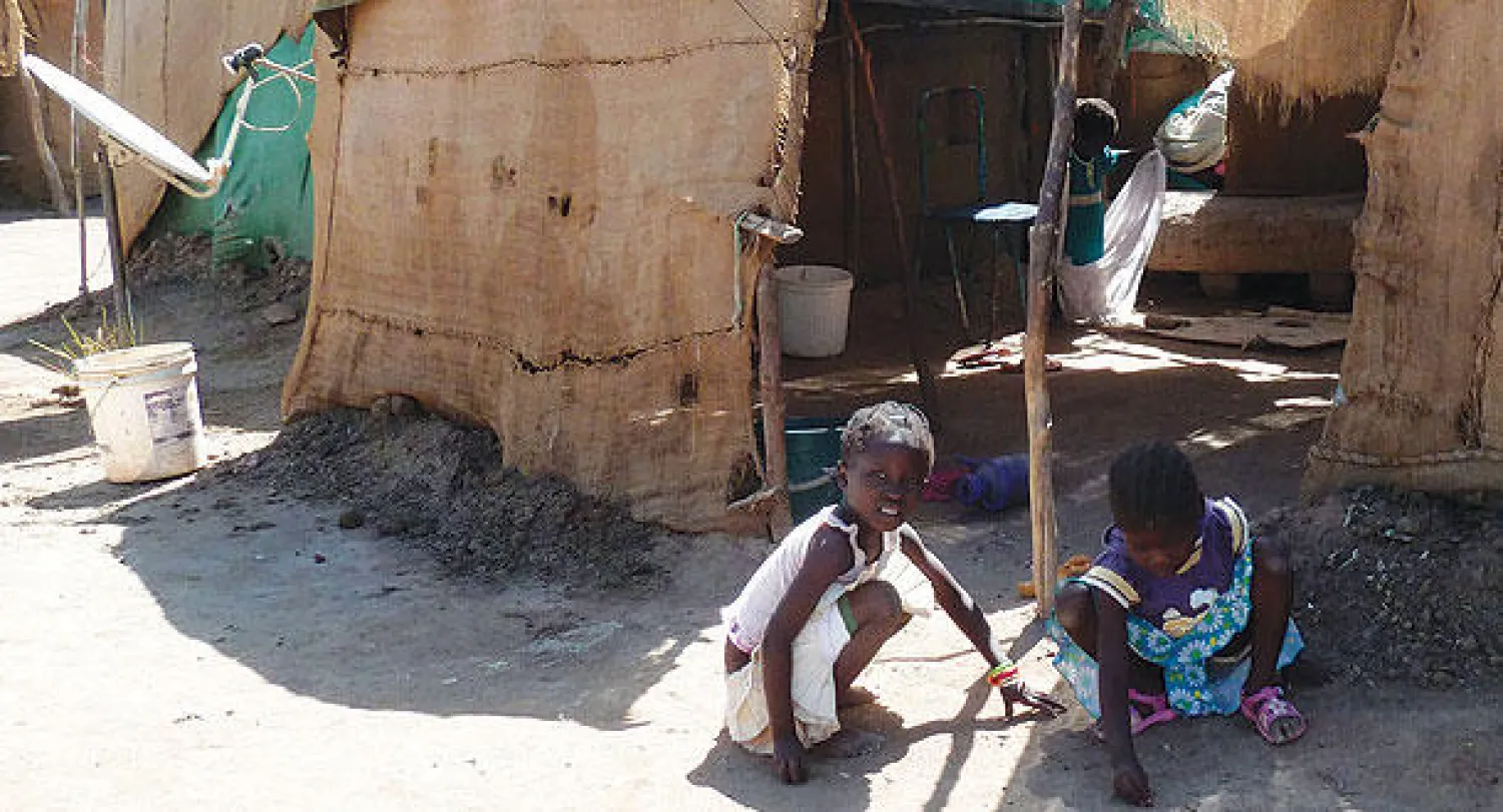 طفلان يلعبان بجوار خيمة في مخيم  دار السلام للاجئين من جنوب السودان الواقع جنوب الخرطوم (أ.ف.ب)