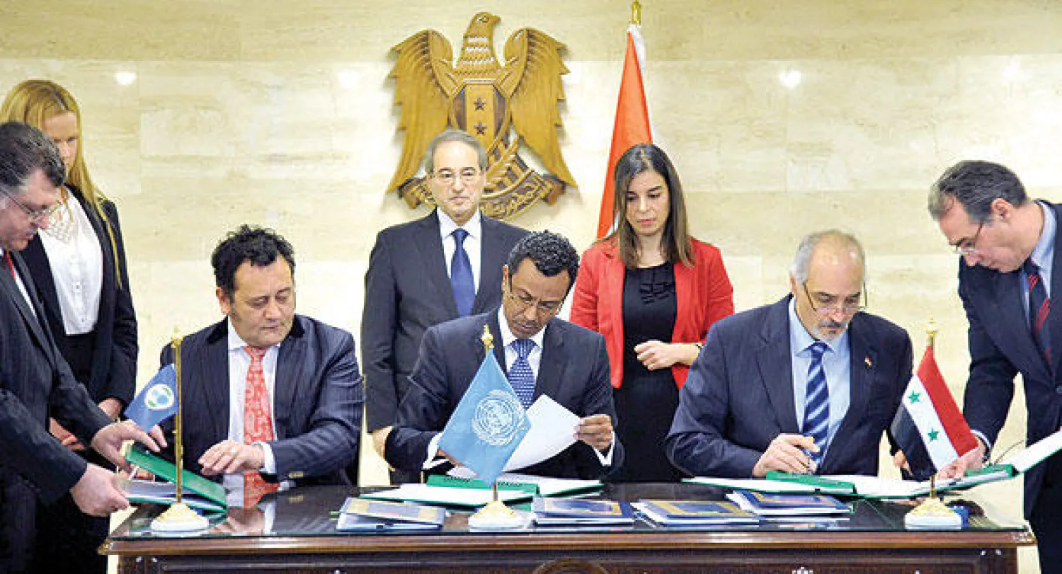 صورة وزعتها «سانا» لتوقيع مذكرة تفاهم بين النظام من جهة والأمم المتحدة ومنظمة حظر الأسلحة الكيماوية من جهة أخرى في دمشق أمس (أ.ف.ب)