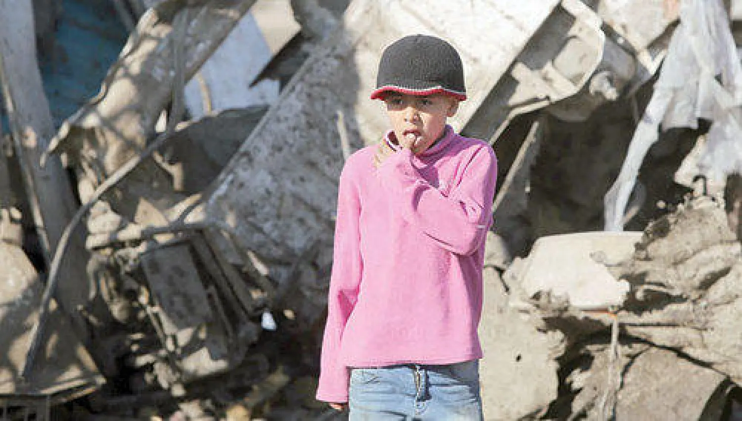 طفل عراقي يقف بين مخلفات تفجير سيارة مفخخة في منطقة العبيدي غرب بغداد حيث انفجرت ست سيارات مفخخة بالعاصمة العراقية أمس (أ.ف.ب)