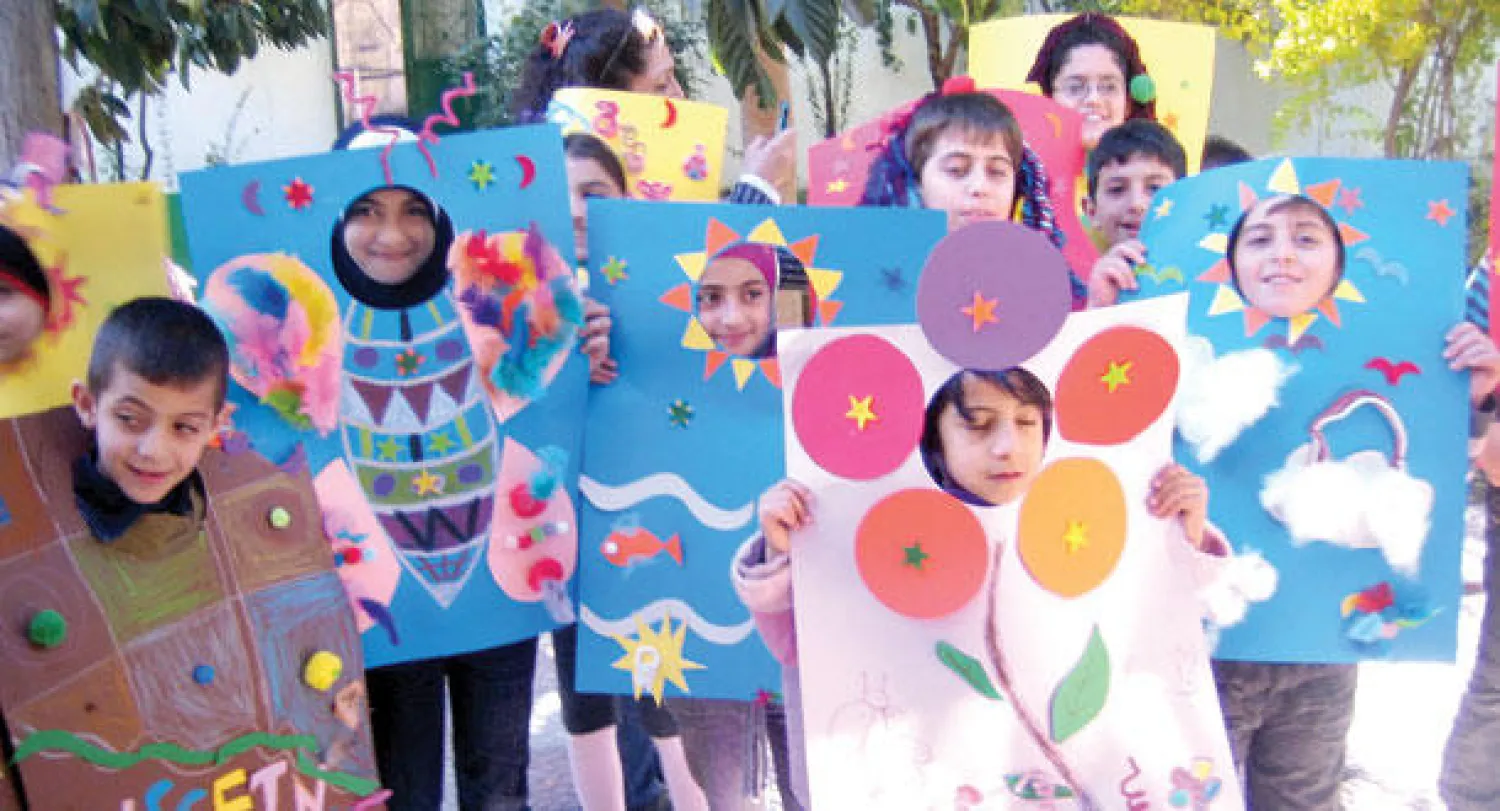 مجموعة من أطفال المحترف مع رسوماتهم