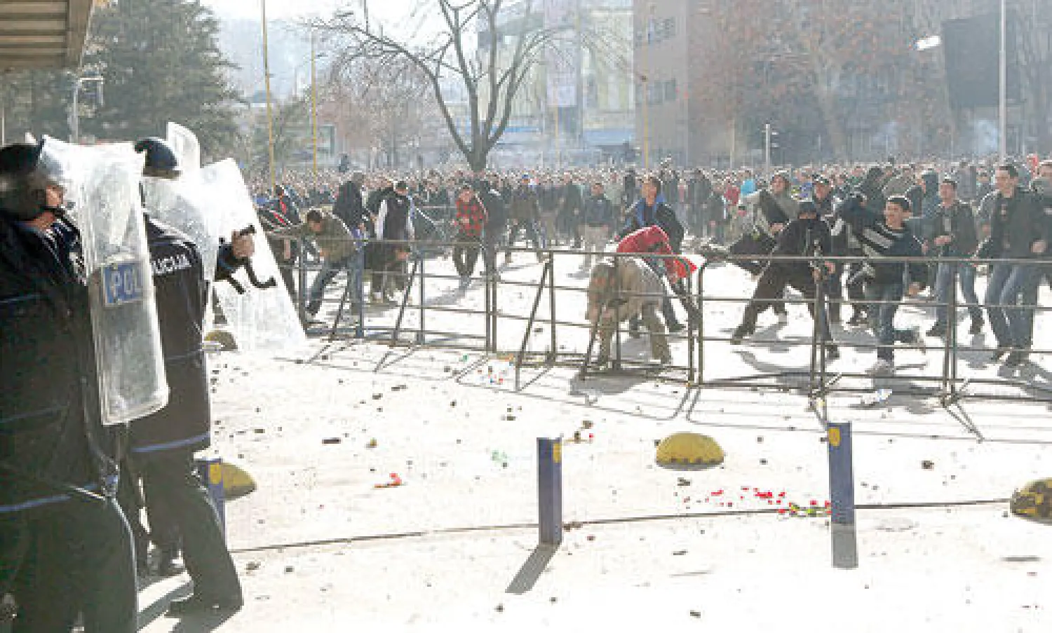 قوات مكافحة الشغب تحاول صد حشد من المتظاهرين أمام مقر للحكومة المحلية في توزلا أمس (أ.ب)