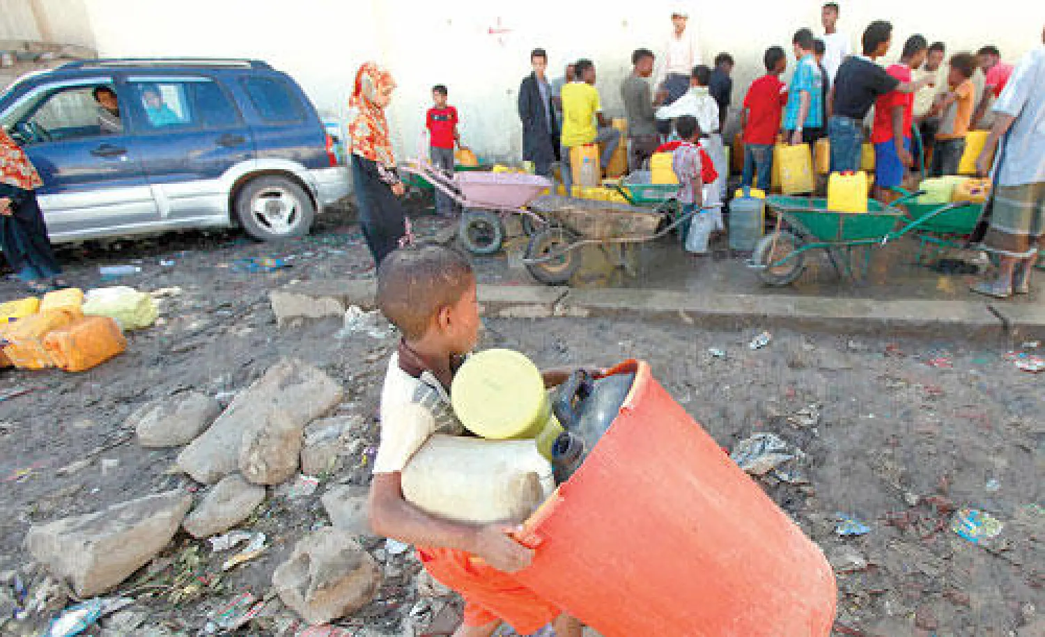 طفل يحمل وعاءين ليملأهما بالمياه في العاصمة صنعاء أمس (رويترز)
