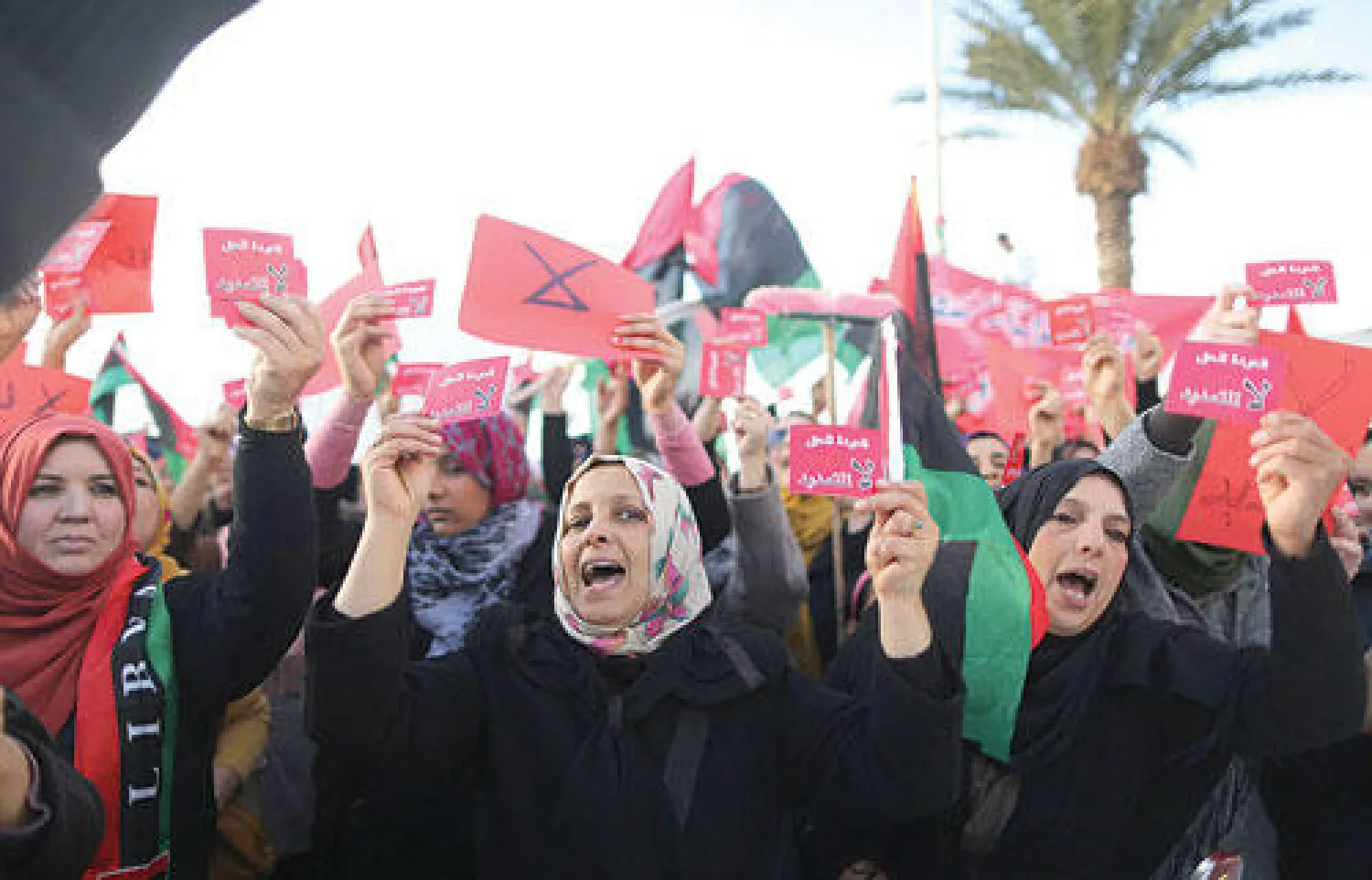 ليبيات يرفعن بطاقات حمراء تدعو إلى عدم التمديد لولاية البرلمان في مظاهرة شهدتها بنغازي أمس (رويترز)