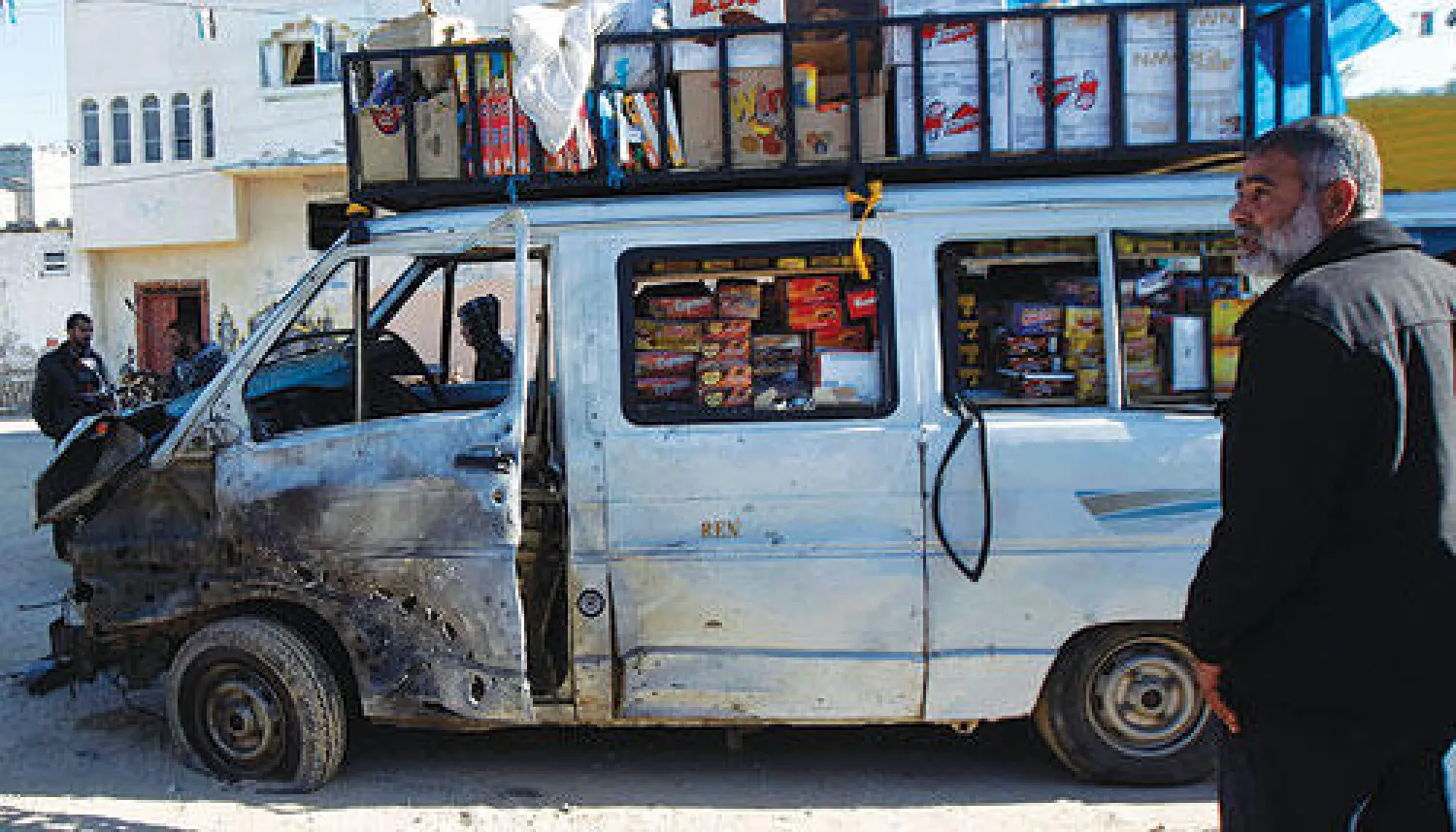 فلسطيني يقف قرب سيارة تعرضت لأضرار بعد غارة إسرائيلية على قطاع غزة أمس (أ.ف.ب)