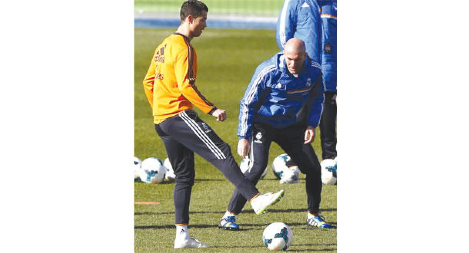 رونالدو نجم ريال مدريد يحاول مراوغة مدربه زيدان خلال تدريبات الفريق أمس (إ.ب.أ)