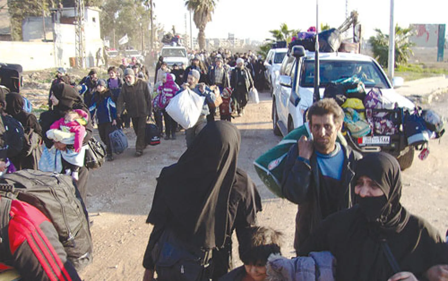 صورة بثت أمس لمدنيين سوريين وهم يغادرون تحت إشراف الأمم المتحدة والهلال الأحمر مدينة حمص المحاصرة أول من أمس (أ.ف.ب)  