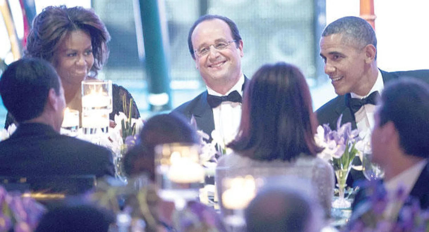 الرئيس الفرنسي يتوسط نظيره الأميركي وحرمه ميشيل أوباما (أ.ف.ب)